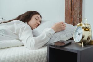Woman sleeping next to alarm clock