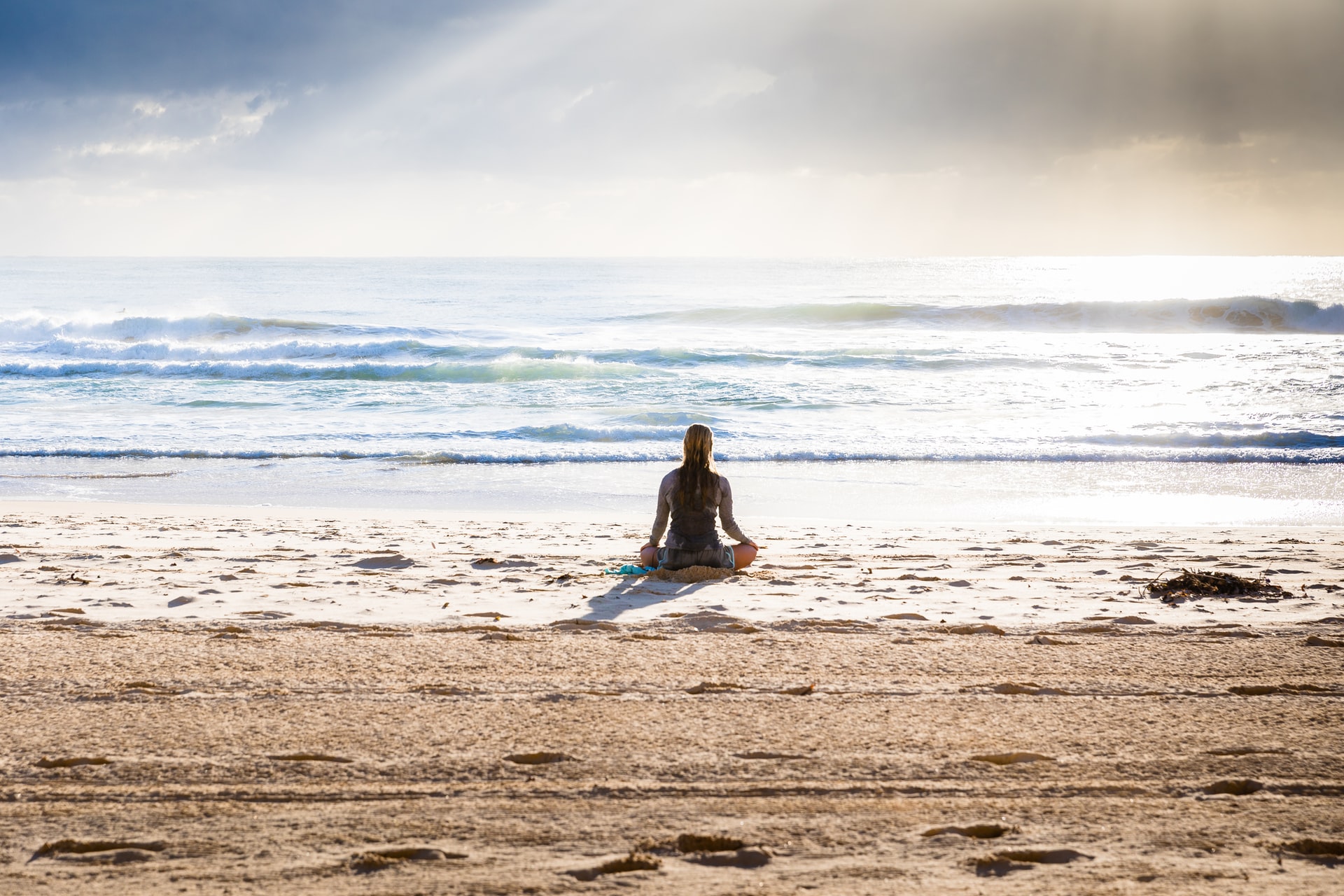 Person meditating on the beach